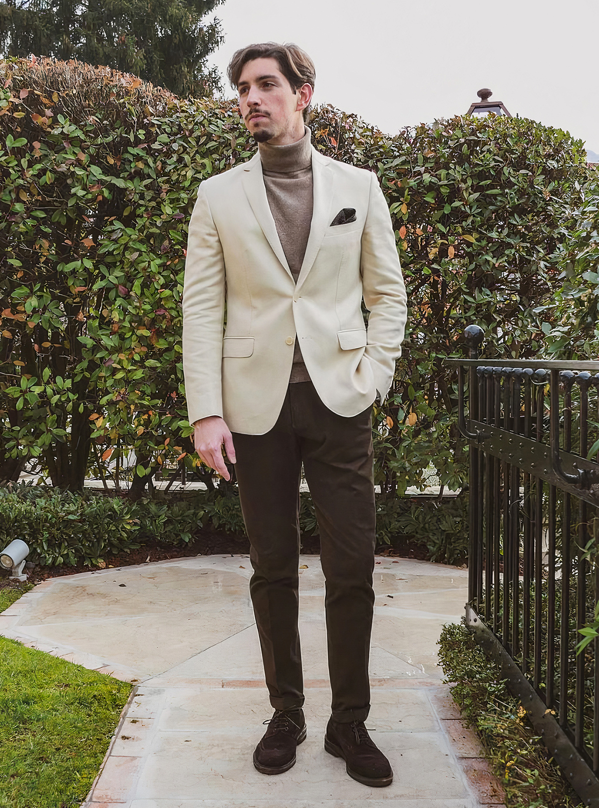 beige blazer, light brown turtleneck, brown chinos, and brown suede brogue shoes