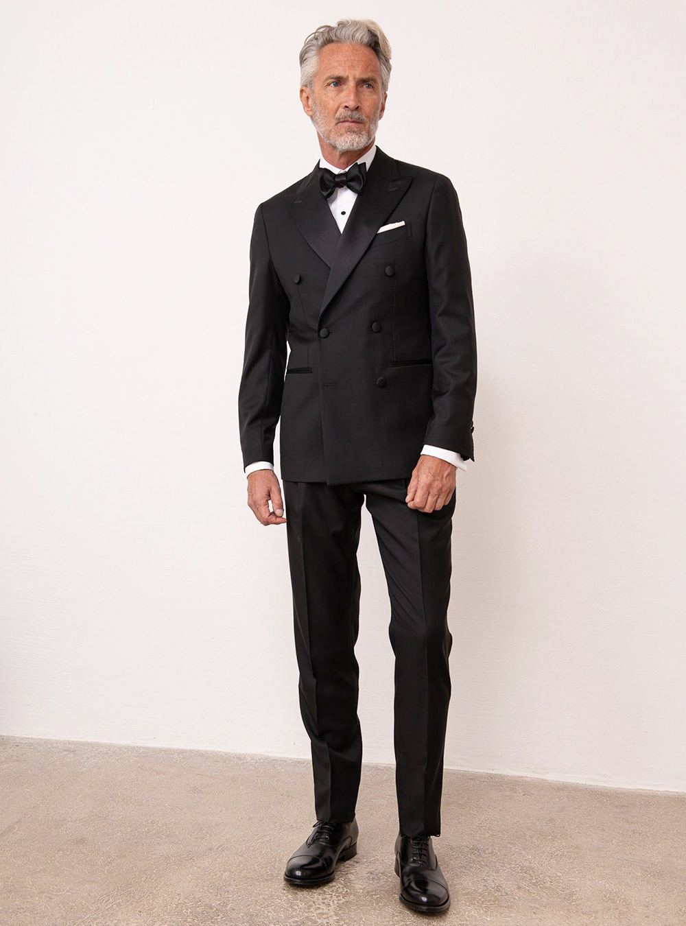 black double-breasted tuxedo, white shirt, black bow tie, and black oxfords