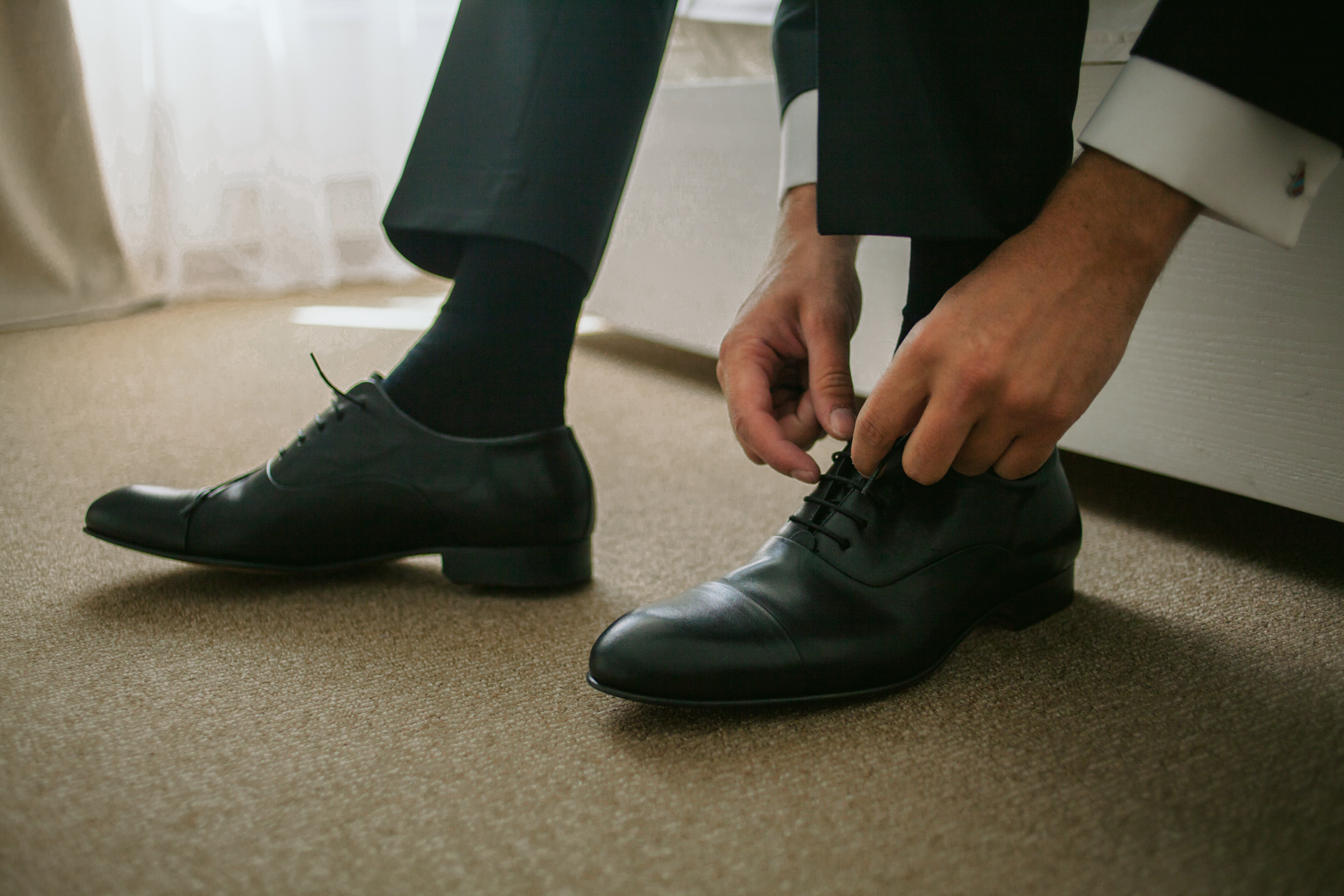 black suit, black socks, and black oxford shoes