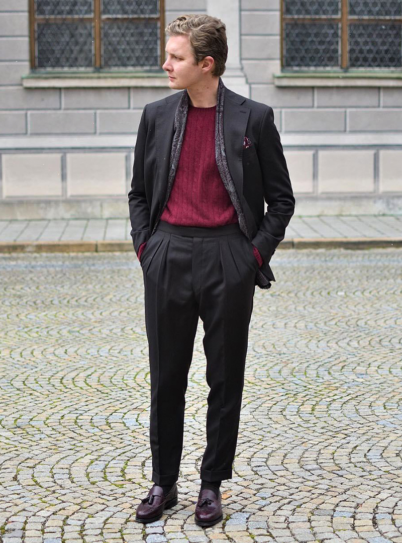 black suit, burgundy sweater, and oxblood tassel loafers