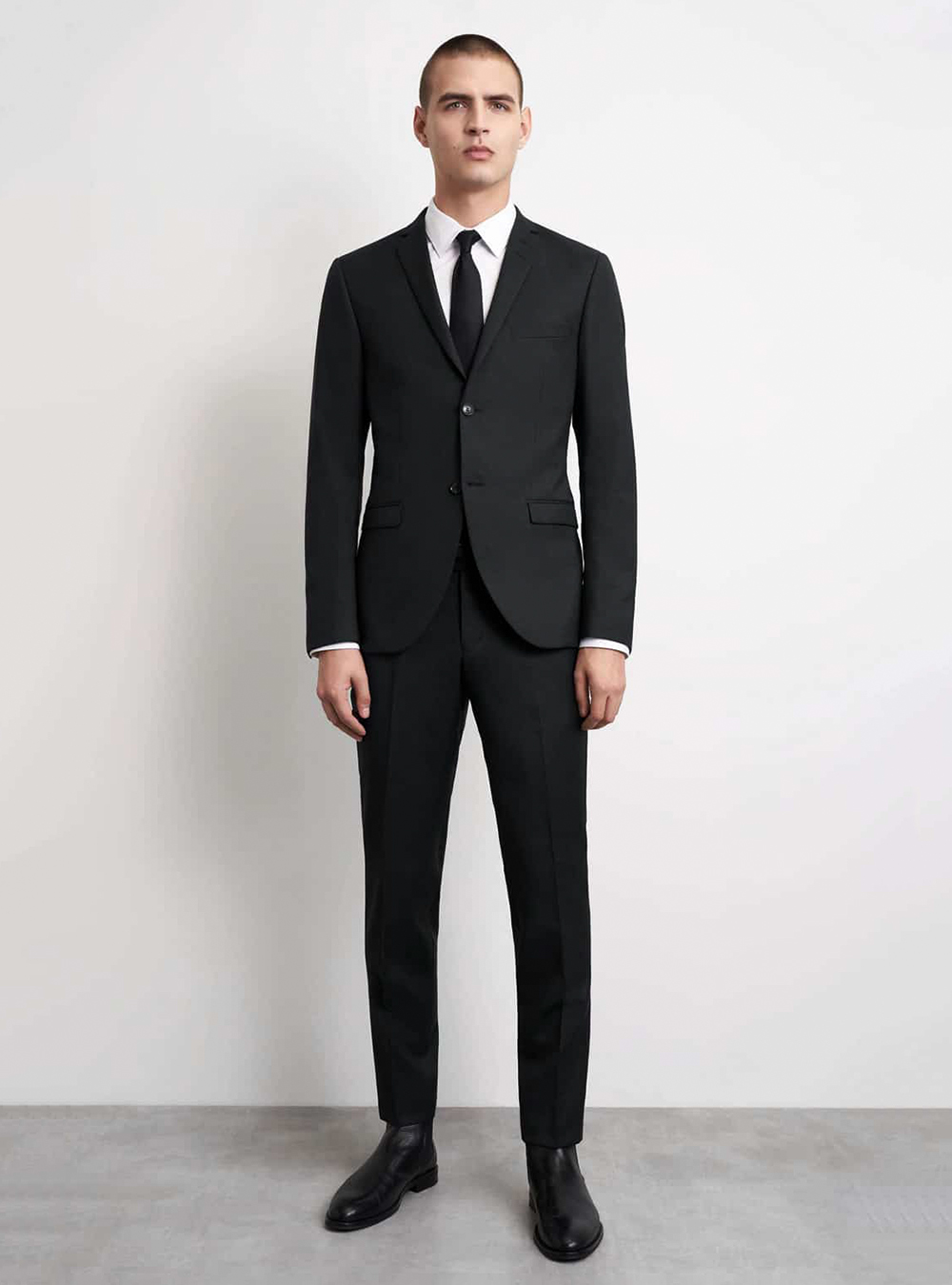black suit, white shirt, black tie, and black Chelseas