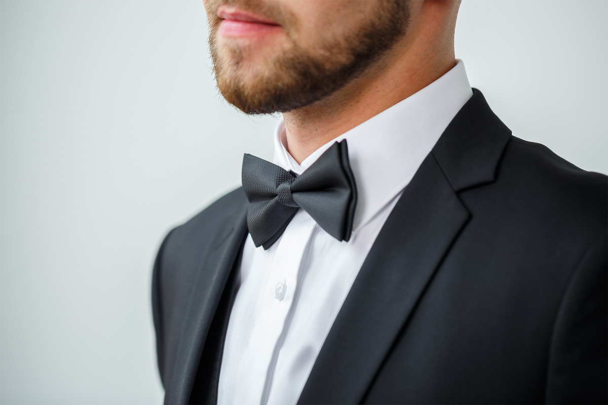 black suit with a white shirt and black bow tie
