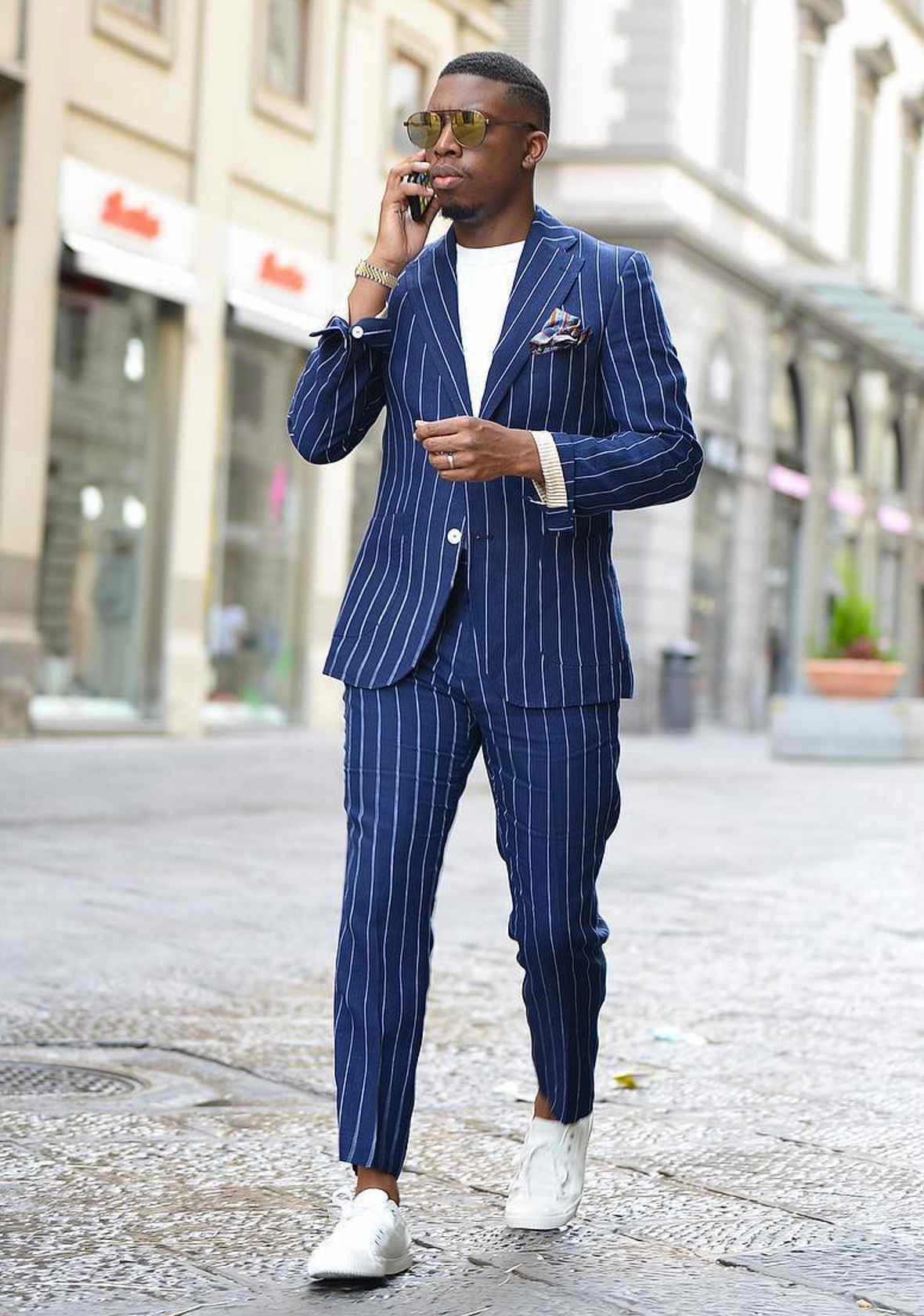 blue pinstripe suit, white t-shirt, and white sneakers
