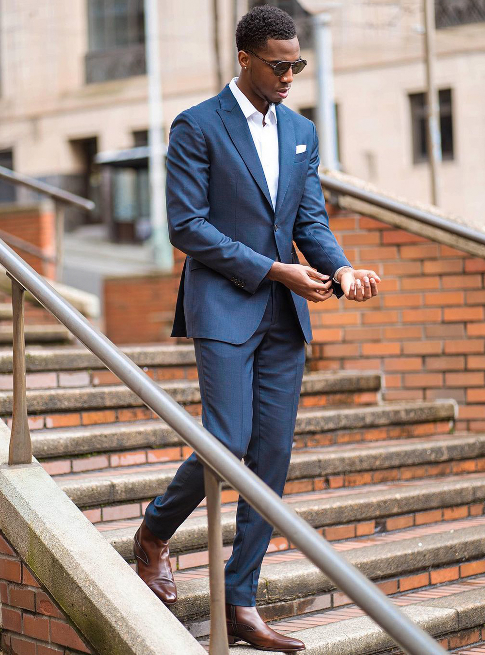blue suit, white dress shirt, and brown Chelsea boots
