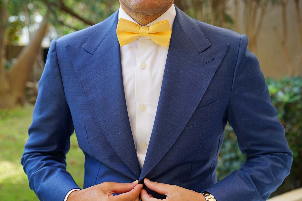 blue suit with a white shirt and yellow tie