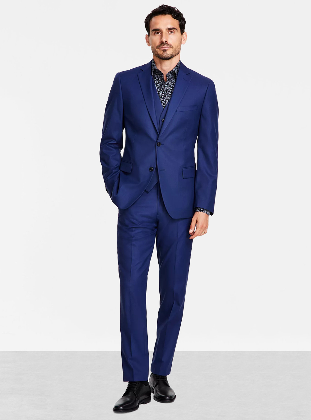 Blue three-piece suit, black and white dress shirt and black derby shoes