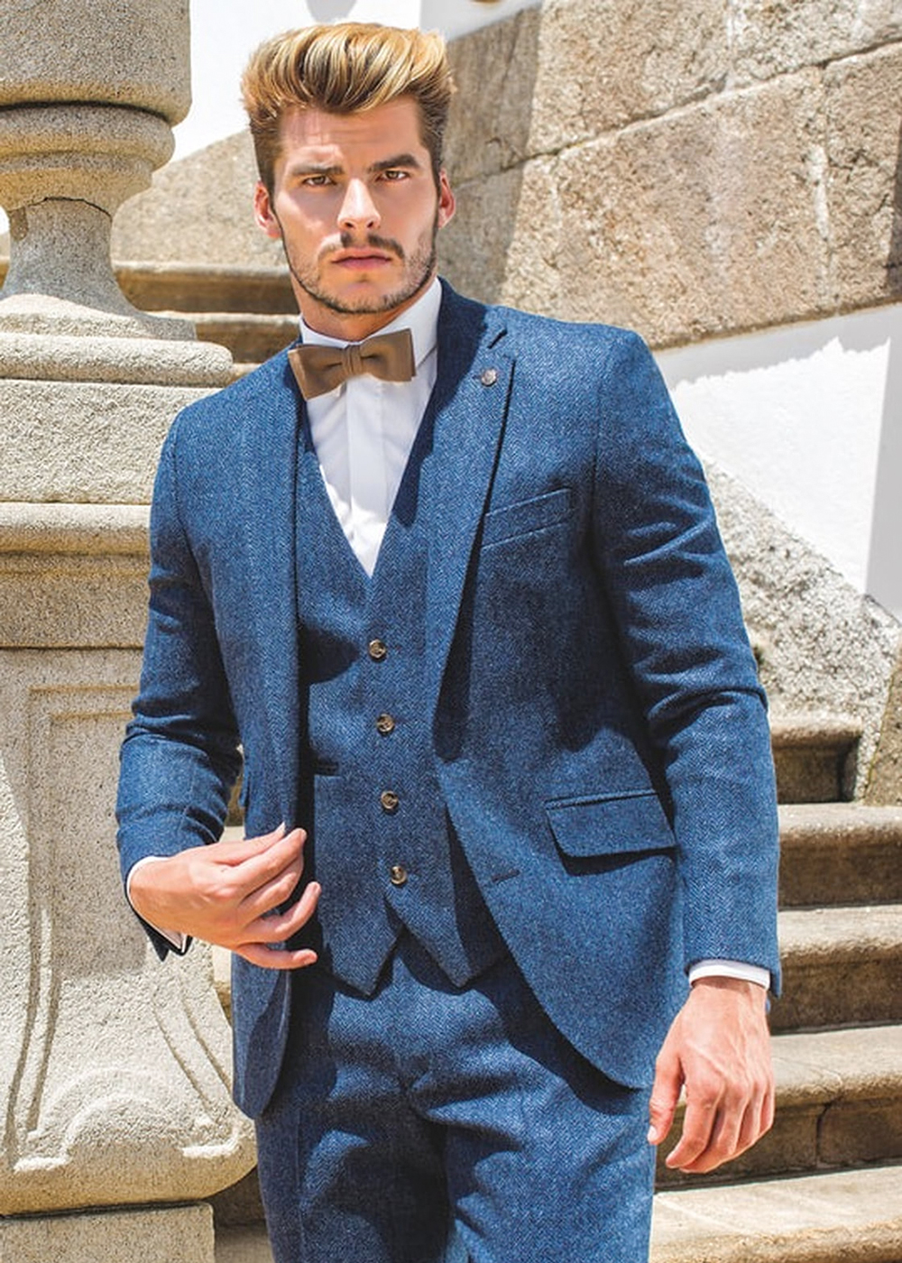 blue tweed suit, white shirt, and brown bow tie