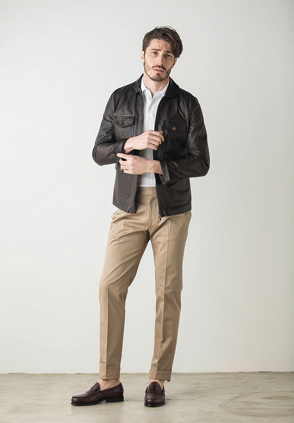 brown biker leather jacket, white shirt, and khaki chinos