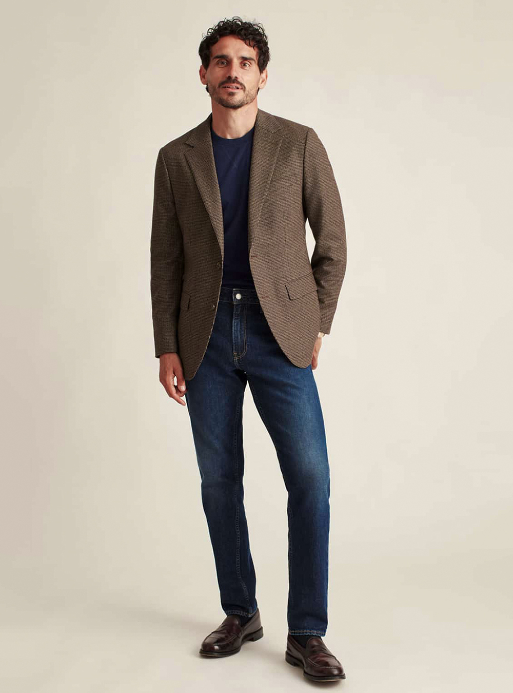 brown blazer, navy t-shirt, blue jeans, and dark brown loafers