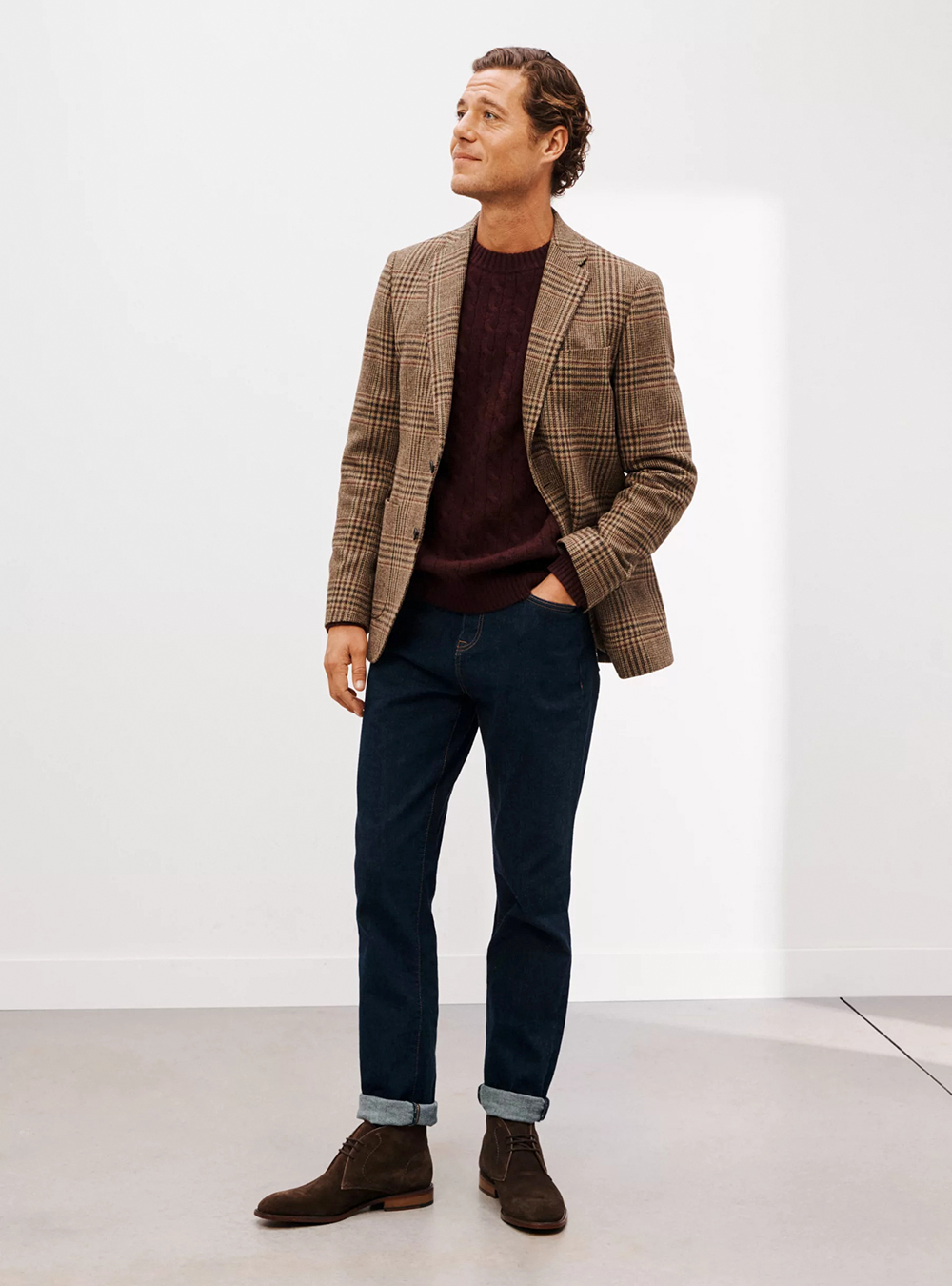 brown plaid blazer, burgundy sweater, dark blue jeans, and brown suede Chukka