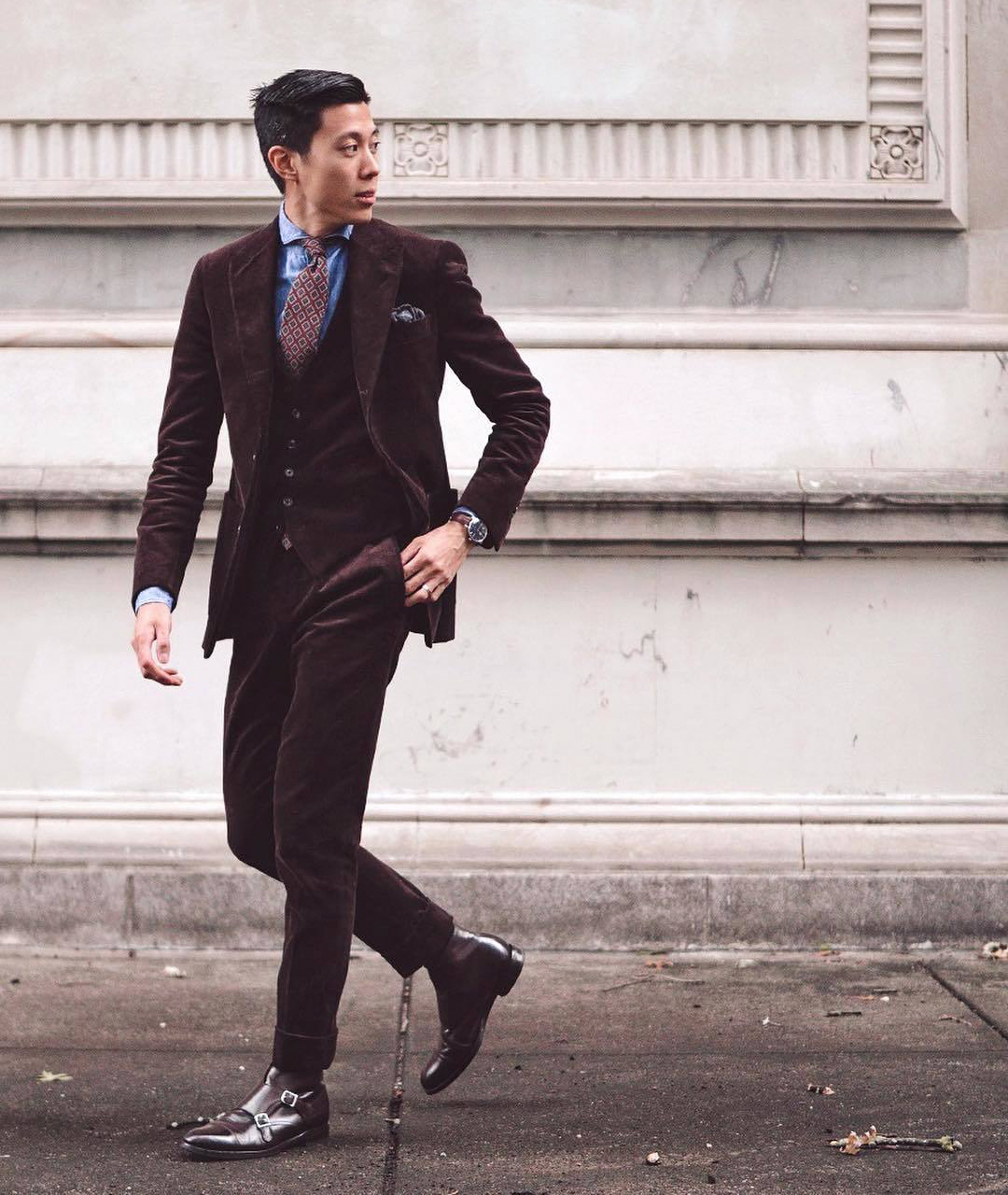 reddish brown three-piece suit paired with brown monk strap dress botos