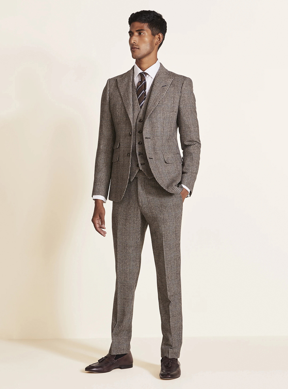 light brown three-piece tweed suit with a white shirt and brown loafers