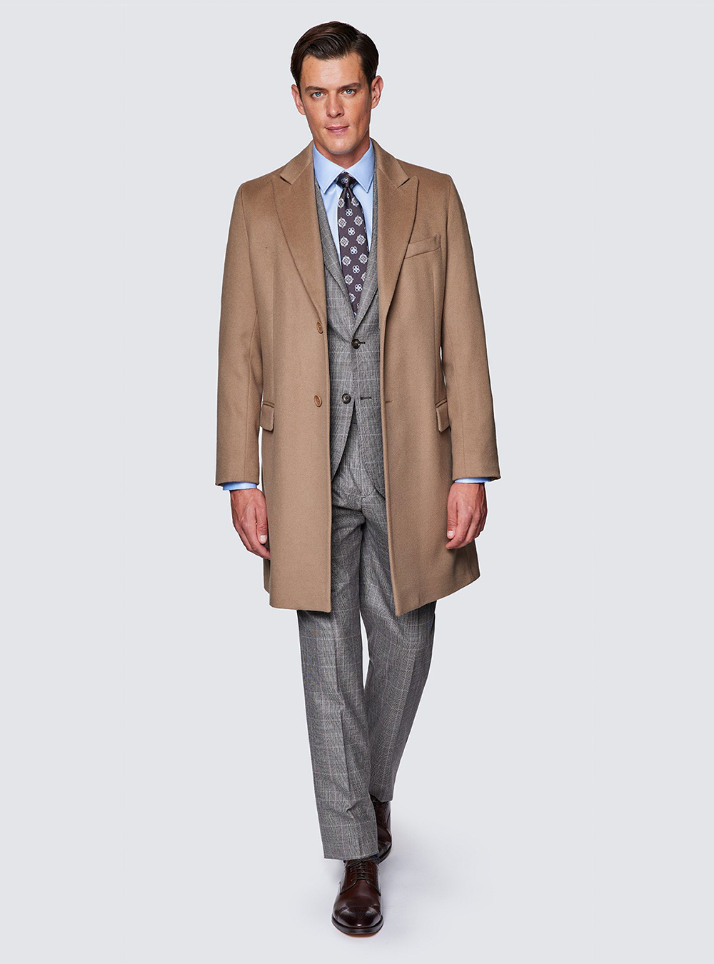 camel overcoat, grey suit, blue shirt, brown tie, and brown brogues