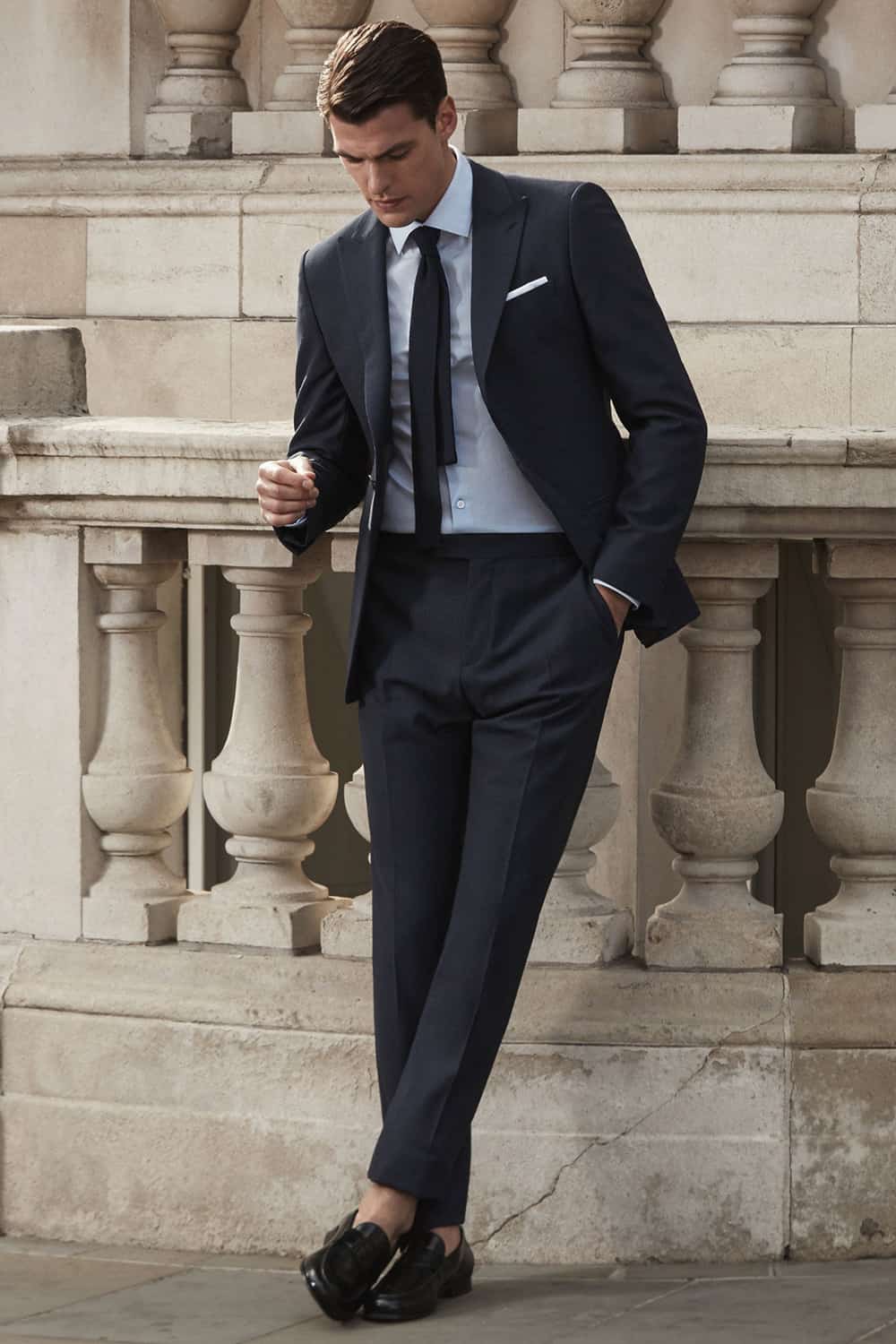 Charcoal grey suit, pale blue shirt, and black loafers