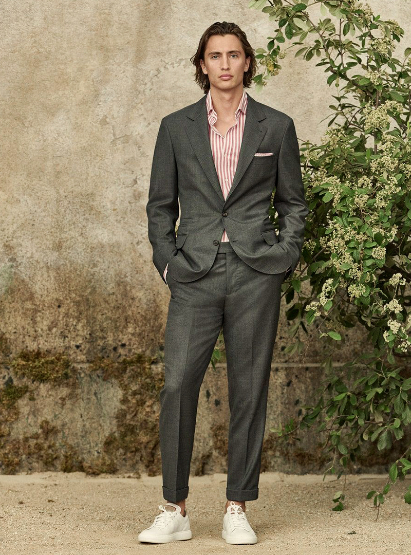 charcoal grey suit, pink striped shirt, and white sneakers