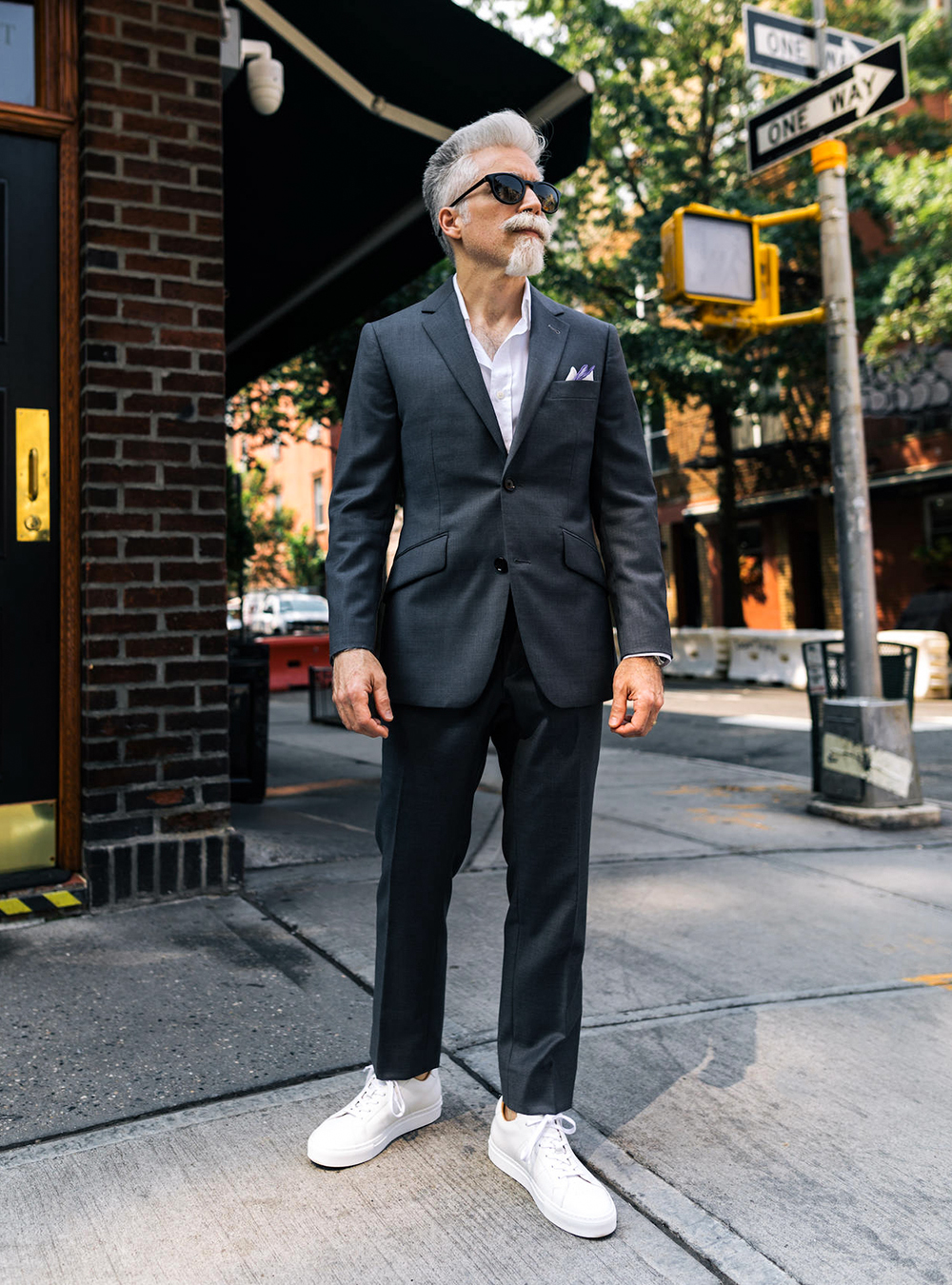charcoal grey suit, white dress shirt, and white sneakers