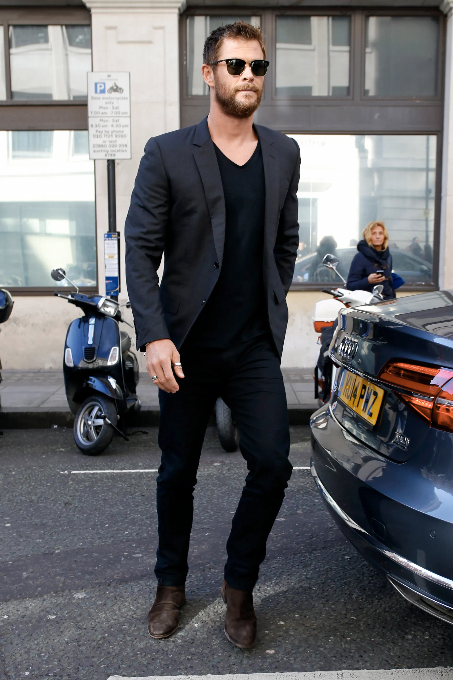 Chris Hemsworth wearing a charcoal suit jacket, black jeans, and black t-shirt