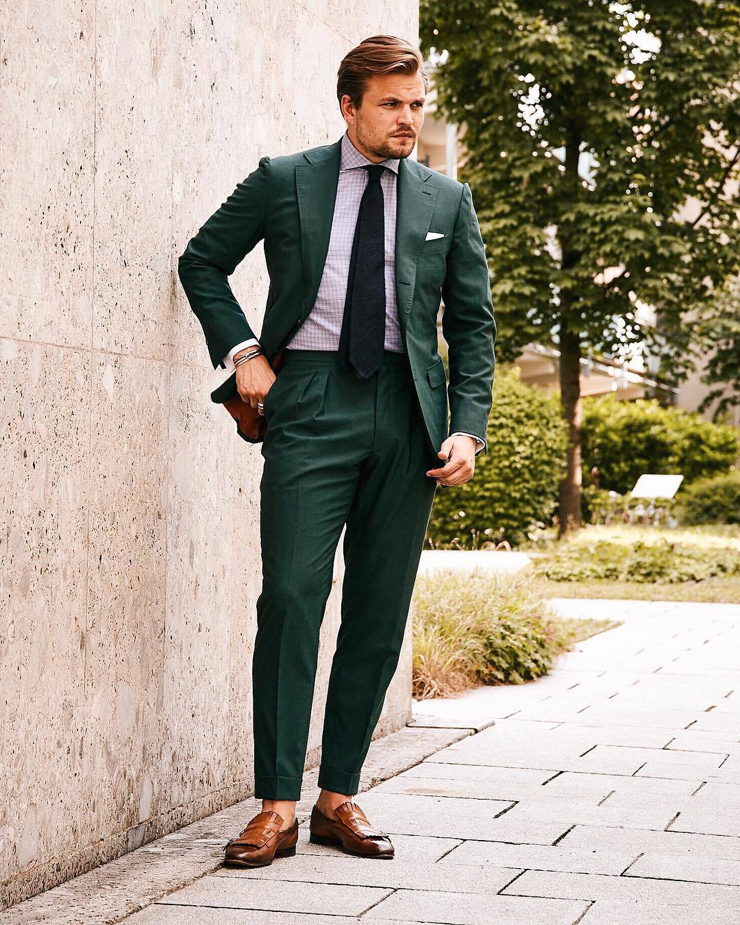 dark green suit, pink patterned shirt, navy tie, and brown loafers