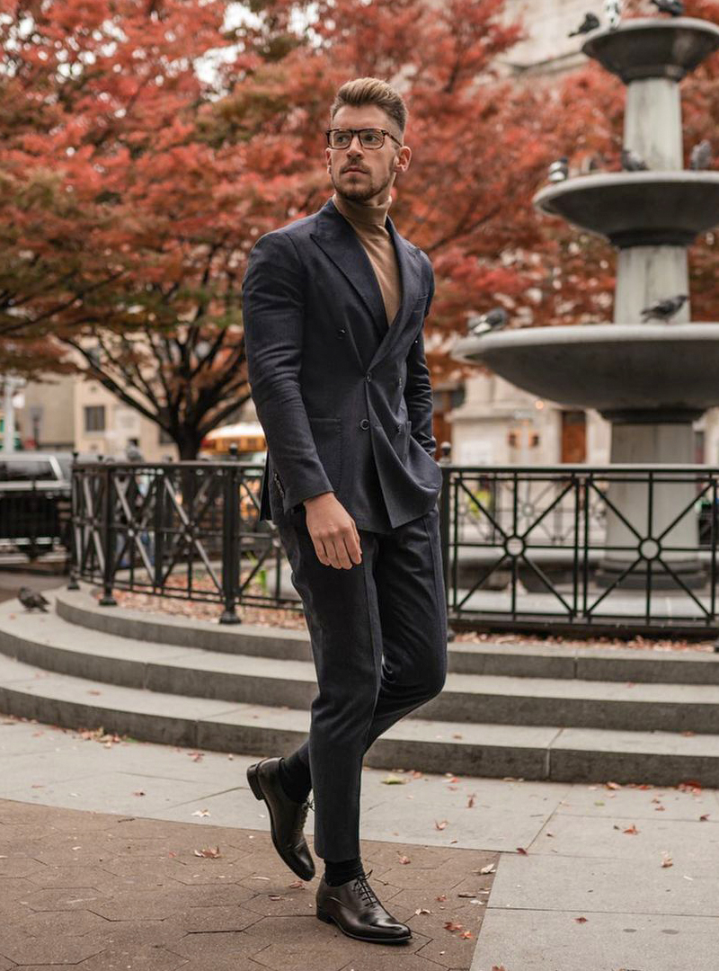 double-breasted charcoal grey suit, orange turtleneck, black oxford shoes