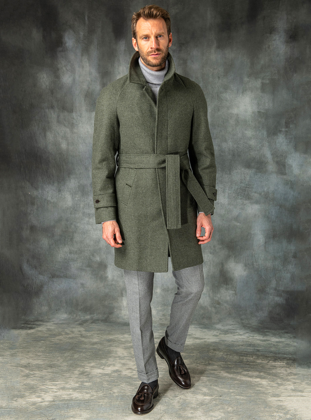 green raglan coat, grey turtleneck, and grey dress pants