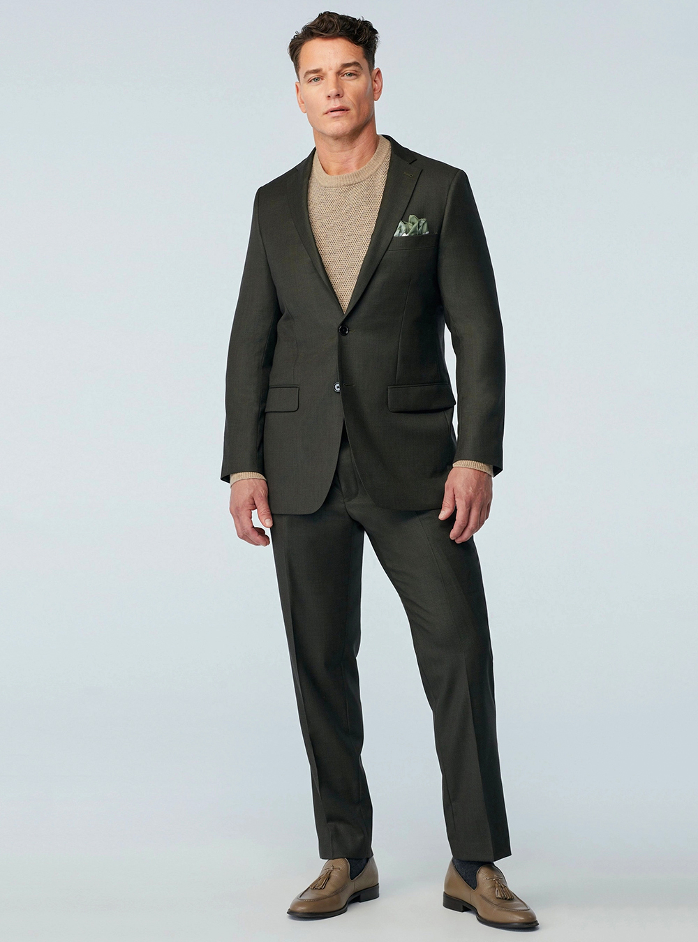 Green suit, beige crew-neck sweater and tan loafers