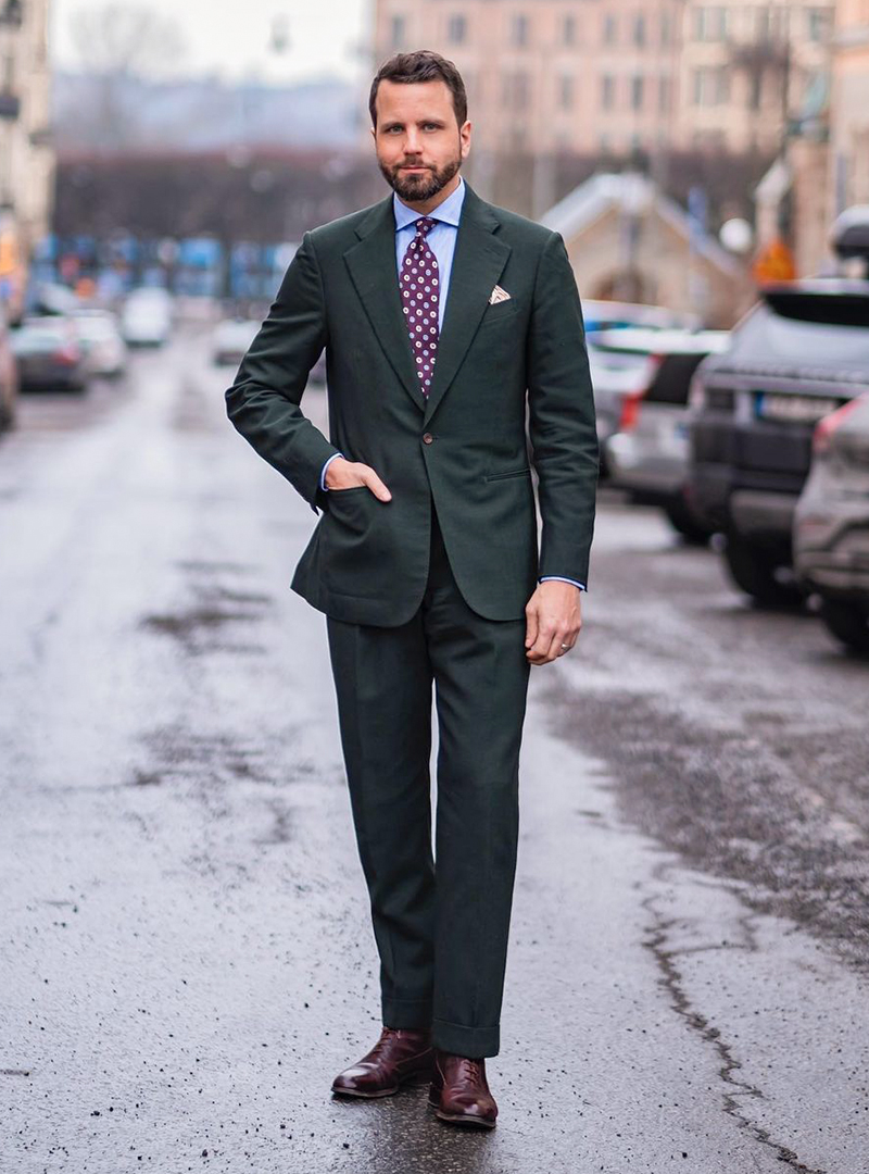 green suit, blue shirt, and burgundy dress boots