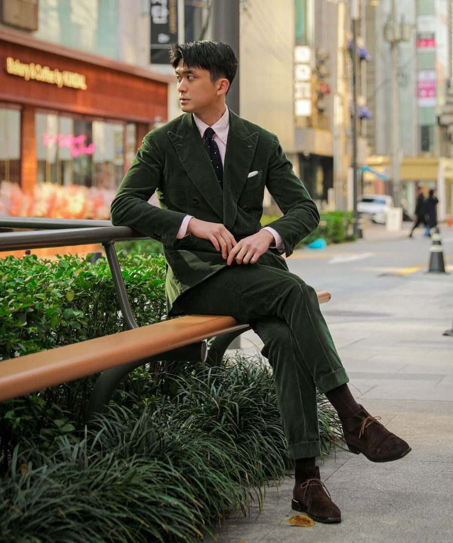 green suit, pink shirt, black polka-dot tie and brown suede chukka boots