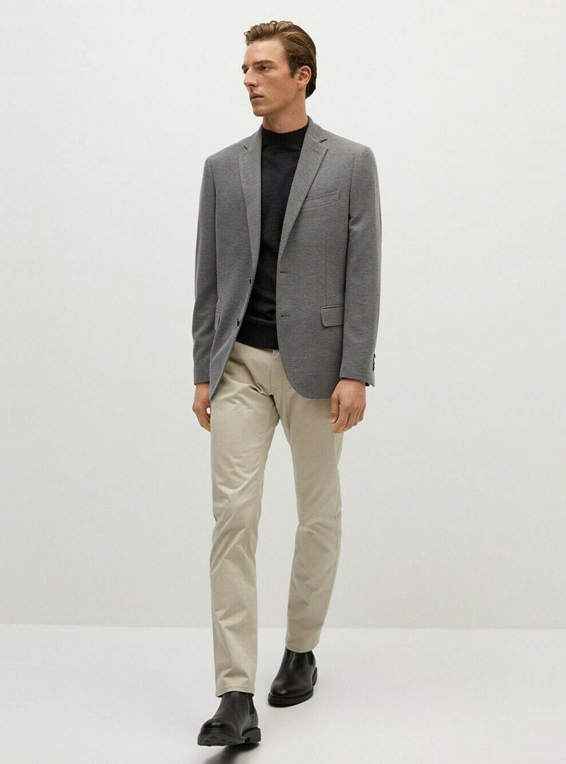 grey blazer, black sweater, beige chinos, and black chelsea boots