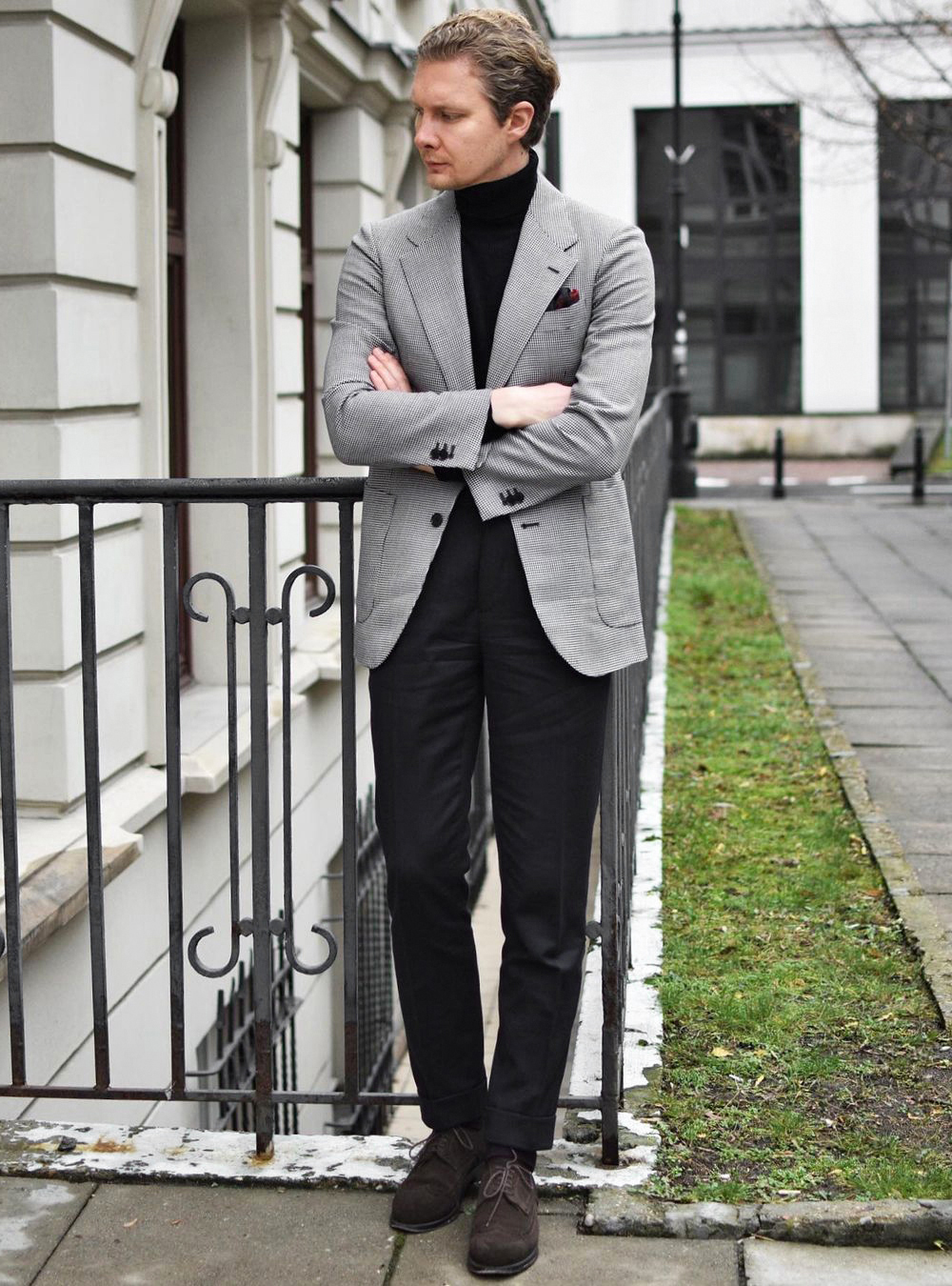grey blazer, black turtleneck, black trousers, and brown derbies