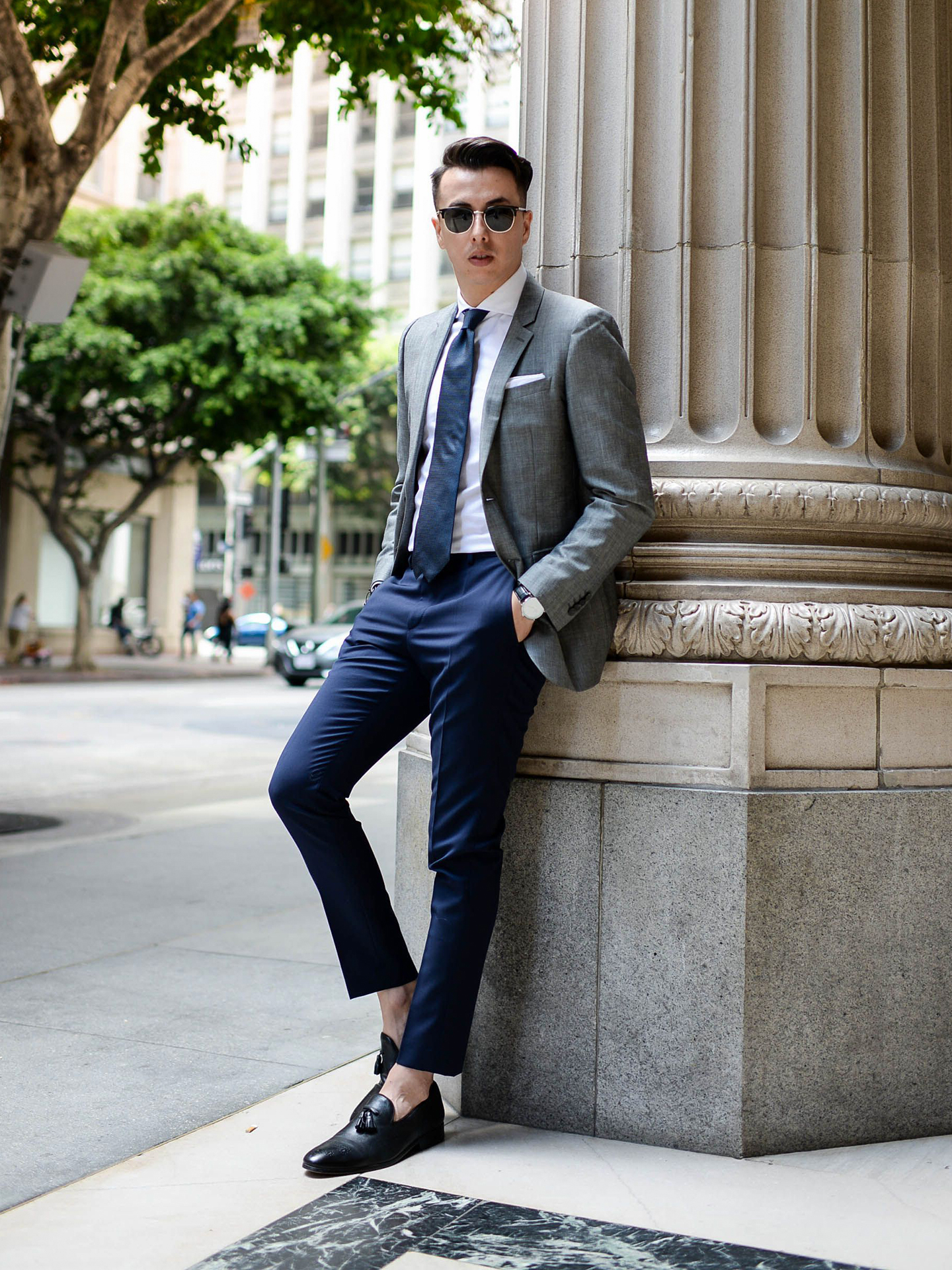 Grey blazer, white shirt, blue tie, navy trousers, and black loafers