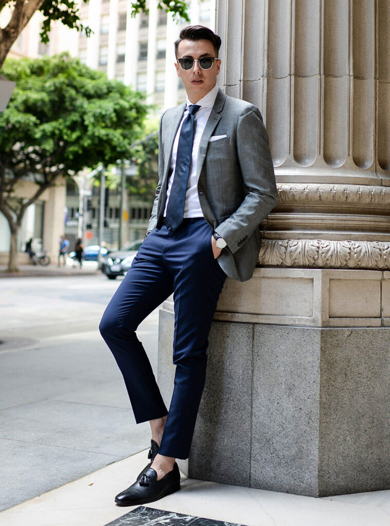 grey blazer, white shirt, blue tie, navy trousers, and black loafers