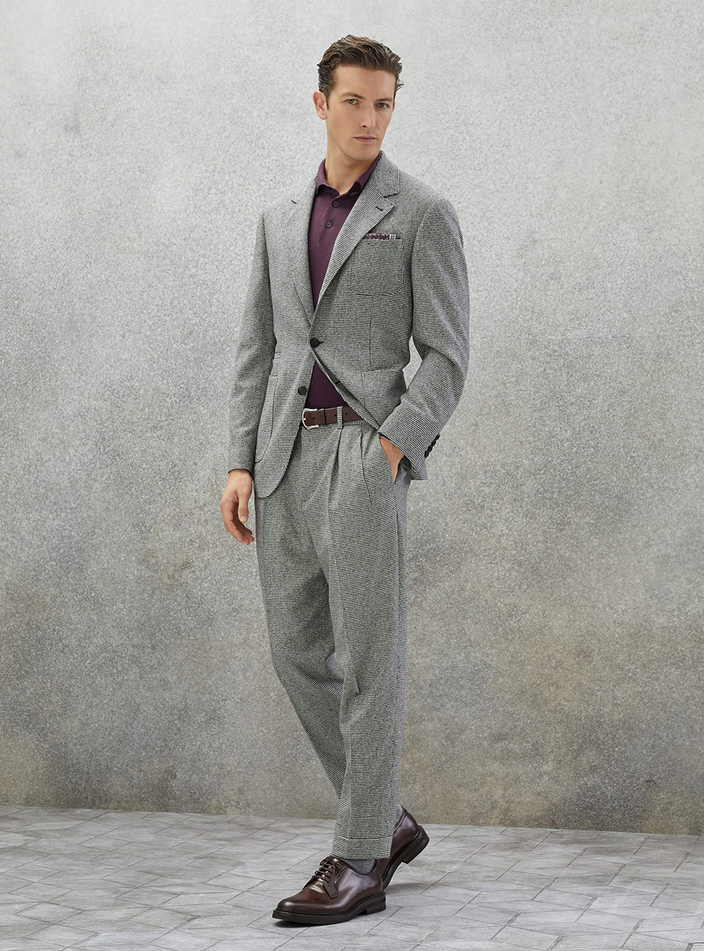 grey houndstooth suit, burgundy polo shirt, and brown derby shoes