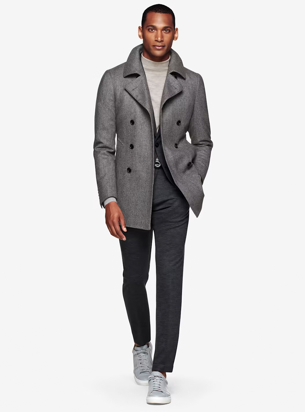 grey pea coat, charcoal-grey suit, light tan turtleneck, and grey sneakers
