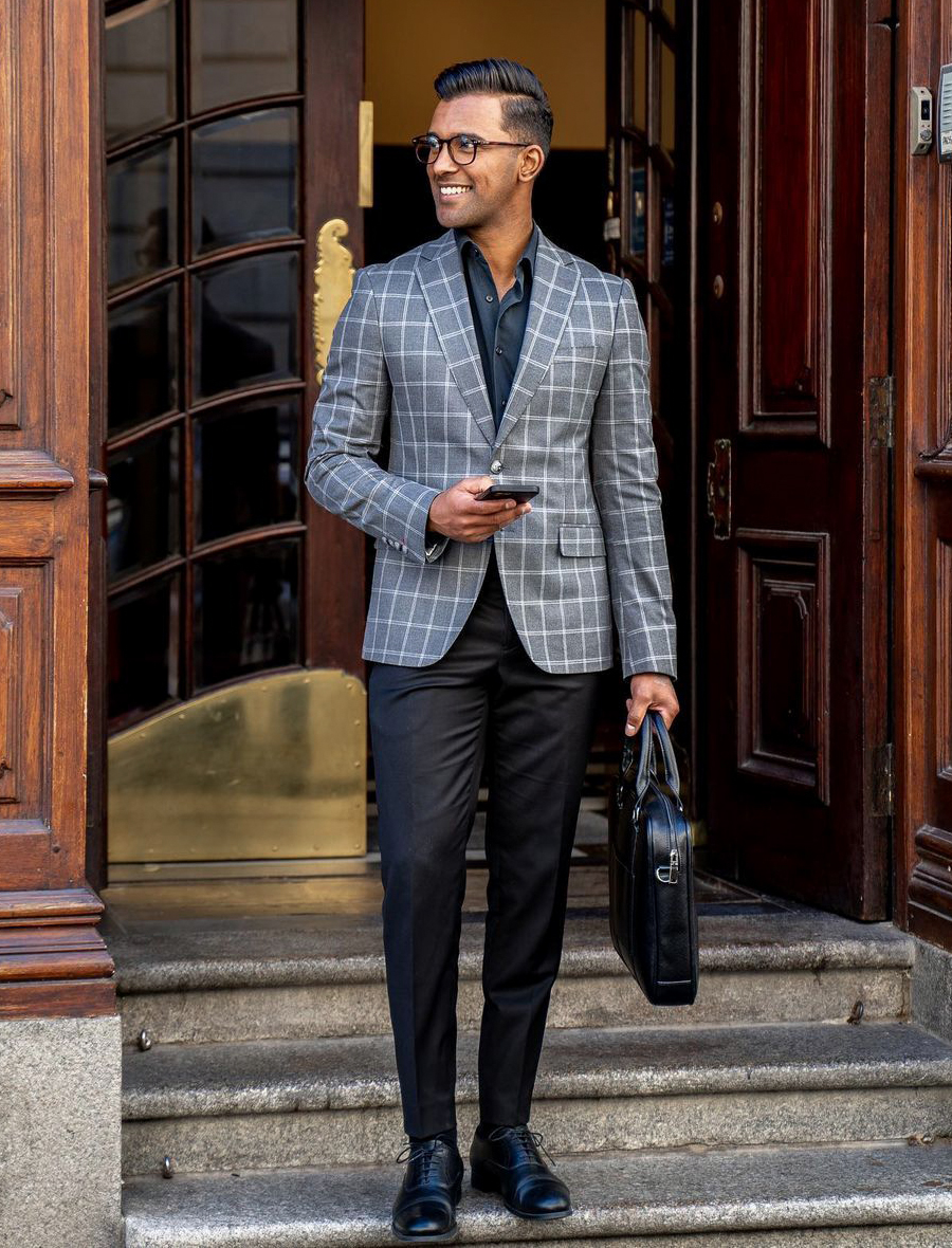 grey plaid blazer, black pants, black shirt, and black shoes