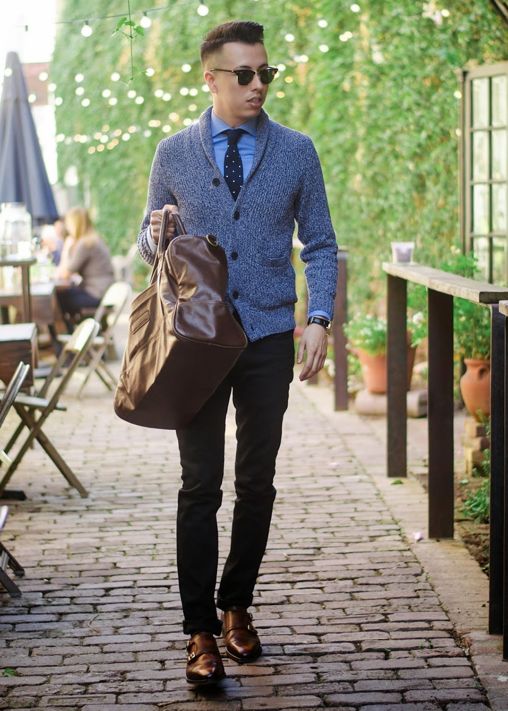 grey cardigan, blue shirt, black jeans, and brown monk straps