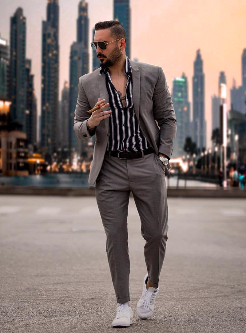 grey suit, black and white long sleeve shirt, and white sneakers