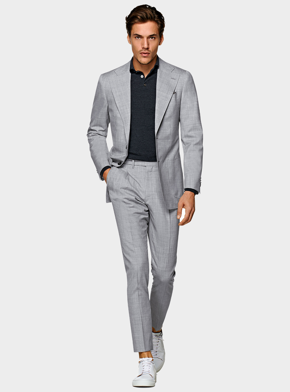 grey suit, black polo t-shirt, and white sneakers