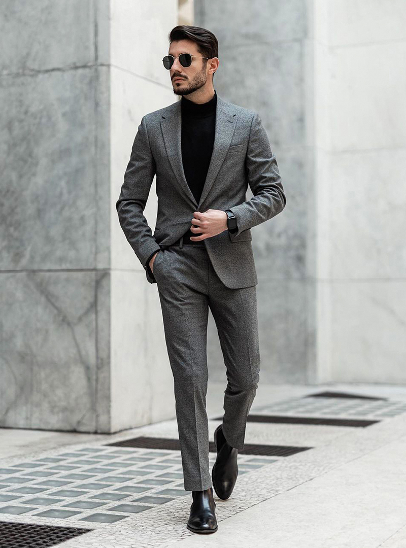 grey suit, black turtleneck, and black Chelsea boots