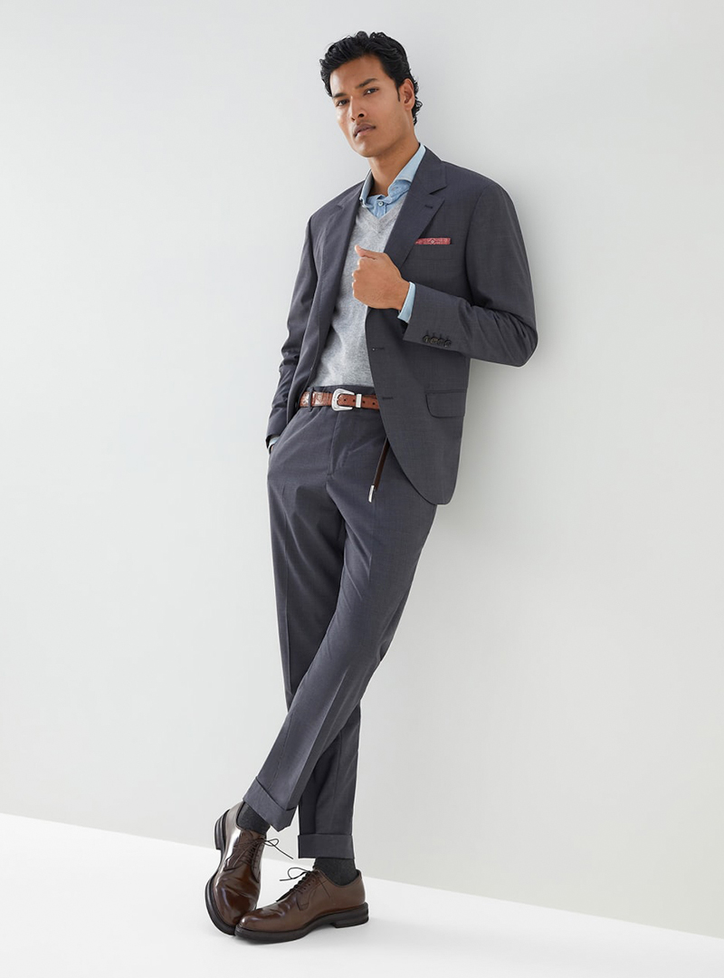 Grey suit, blue shirt, light grey v-neck sweater and brown derby shoes