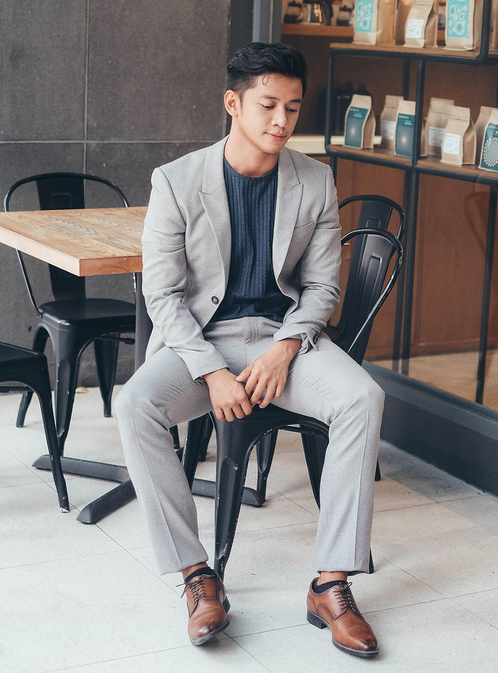 grey suit, navy crew-neck sweater, brown derbies