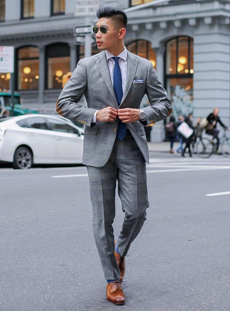 Grey suit, white shirt, blue tie, and brown derby brogue shoes