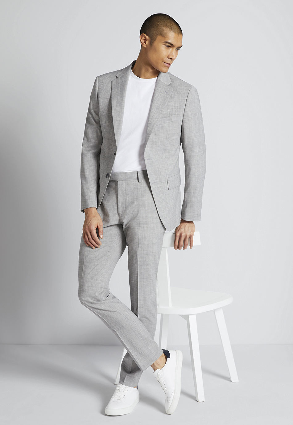 grey suit, white t-shirt, and white sneakers