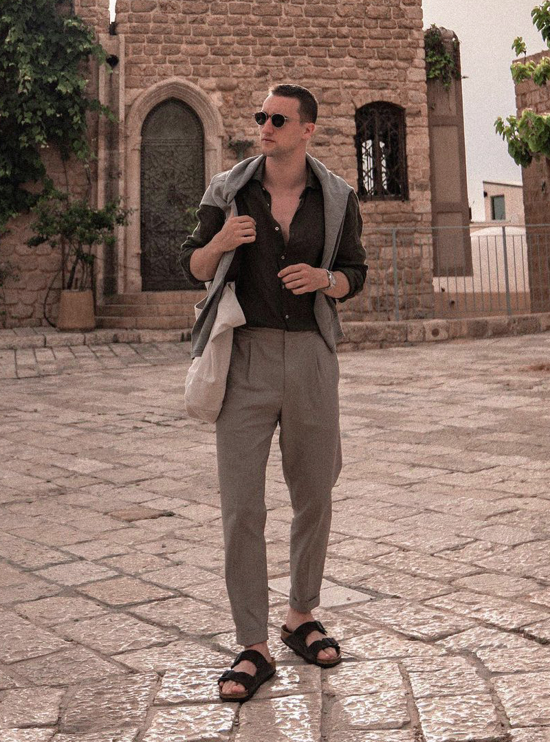 grey sweater over black shirt, grey pants, and black sandals