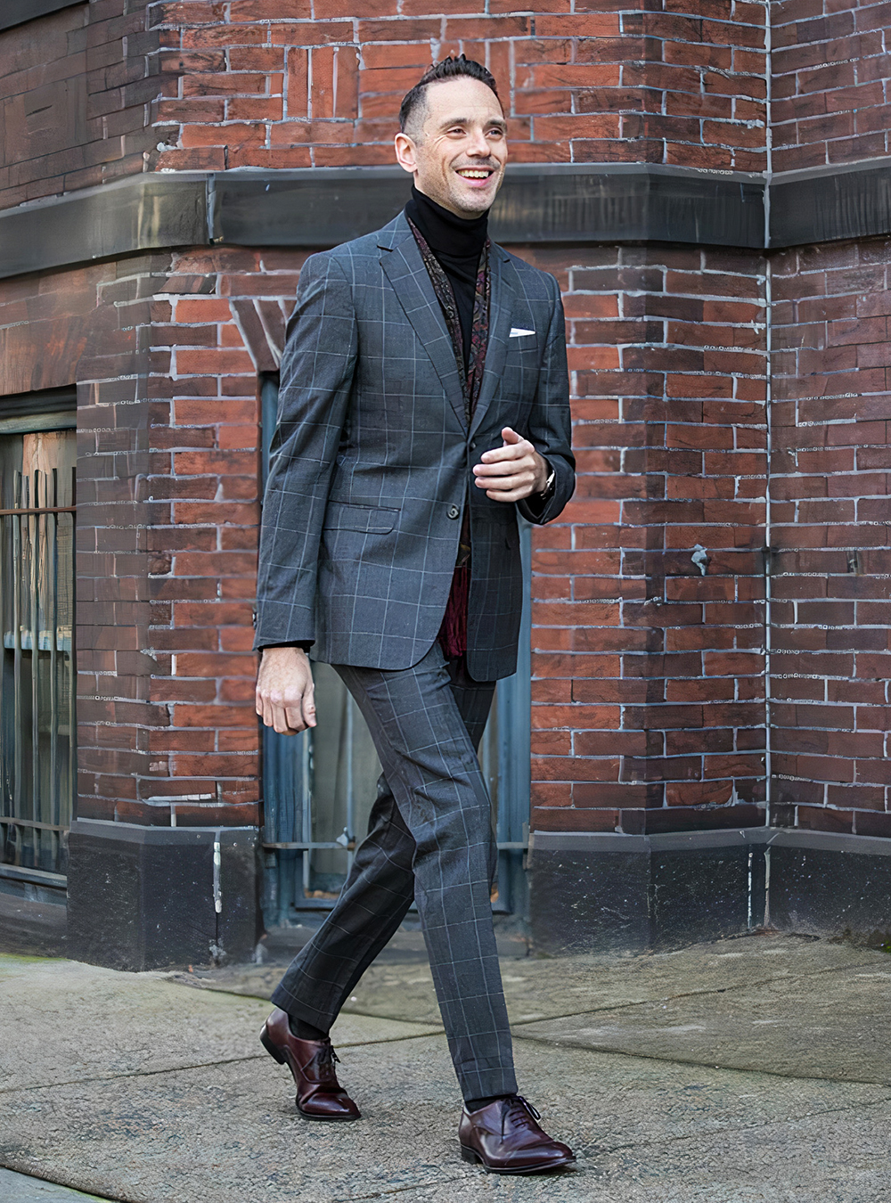 grey windowpane suit, black turtleneck, red scarf, and brown oxford shoes