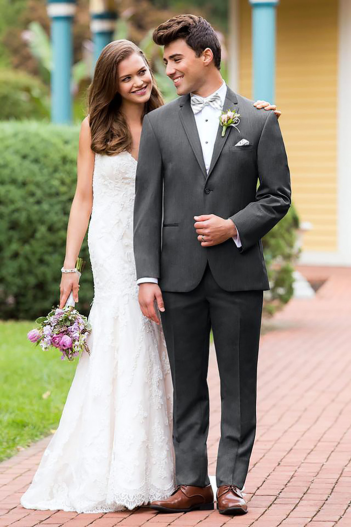 groom wears grey wedding suit and brown derby shoes