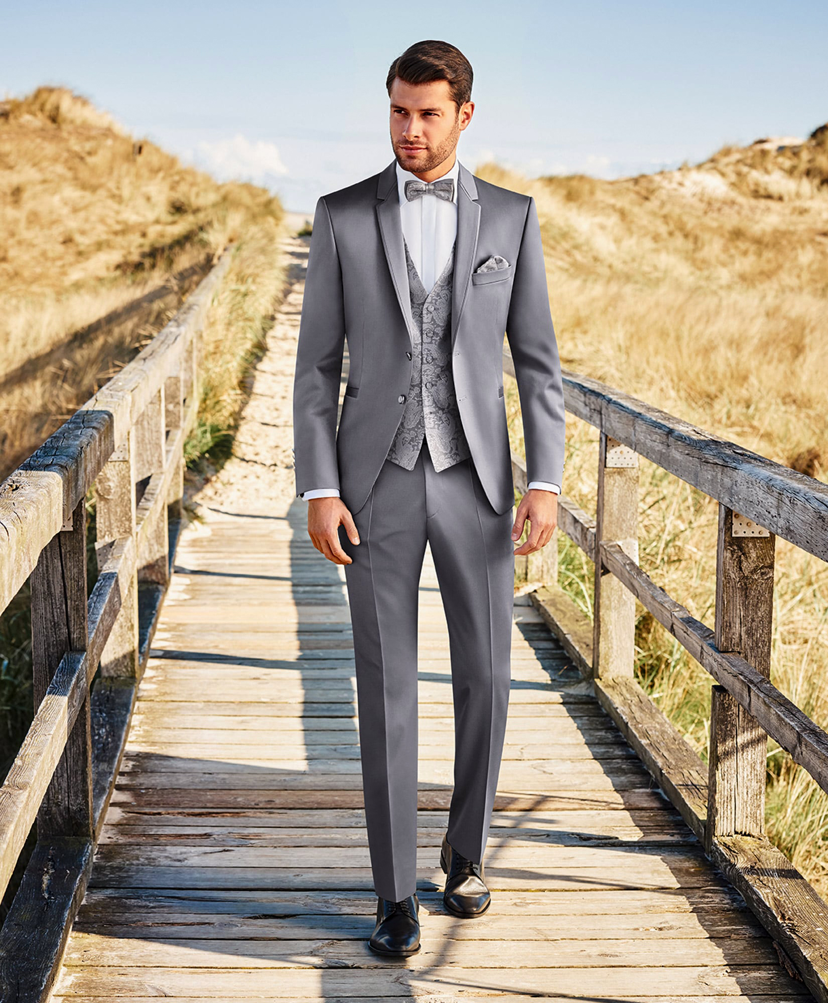 three-piece grey wedding suit and black shoes