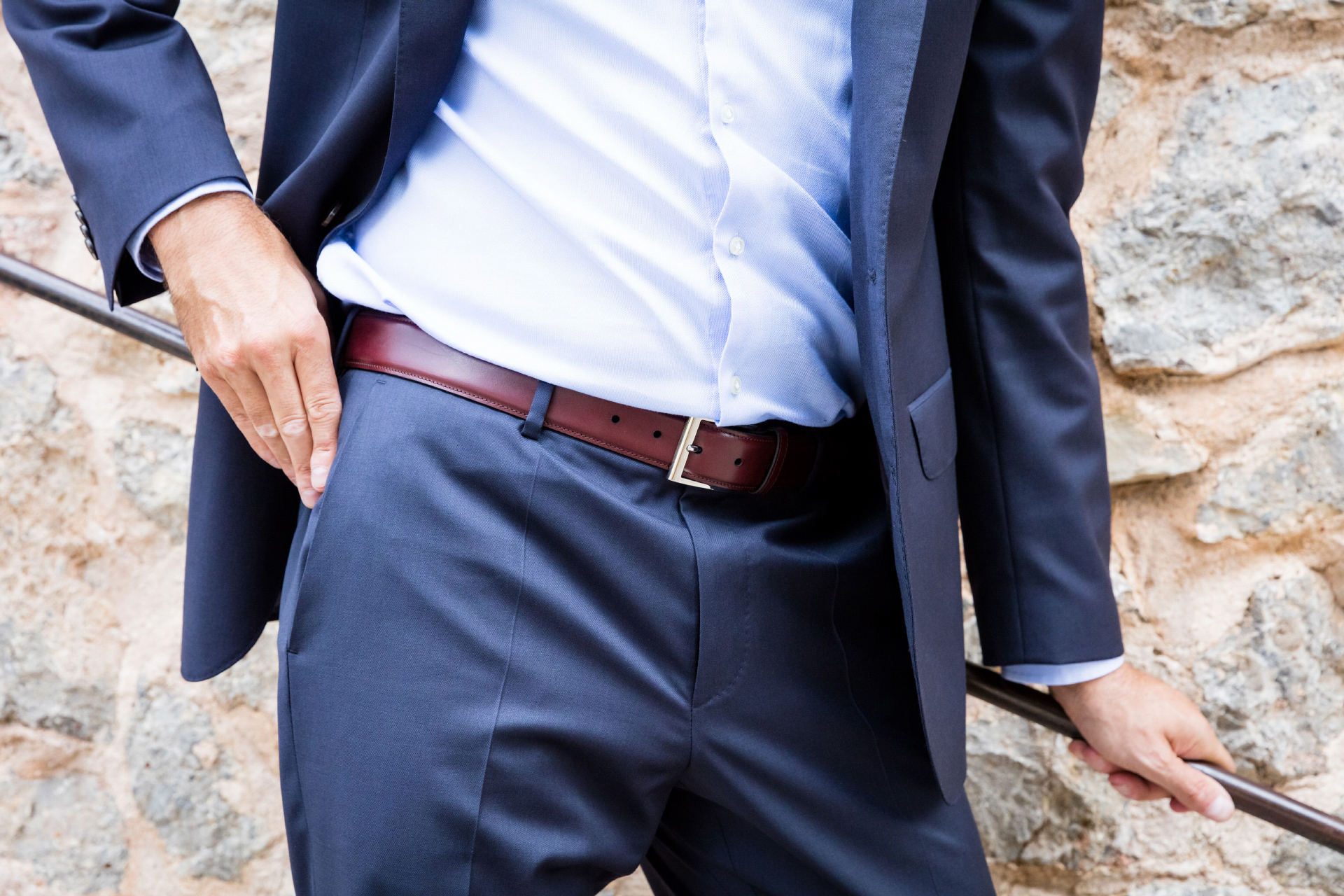 wearing burgundy belt with a navy blue suit