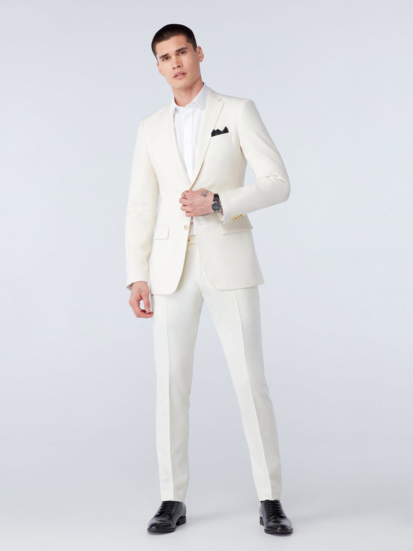 ivory white suit, white dress shirt, and black derby shoes