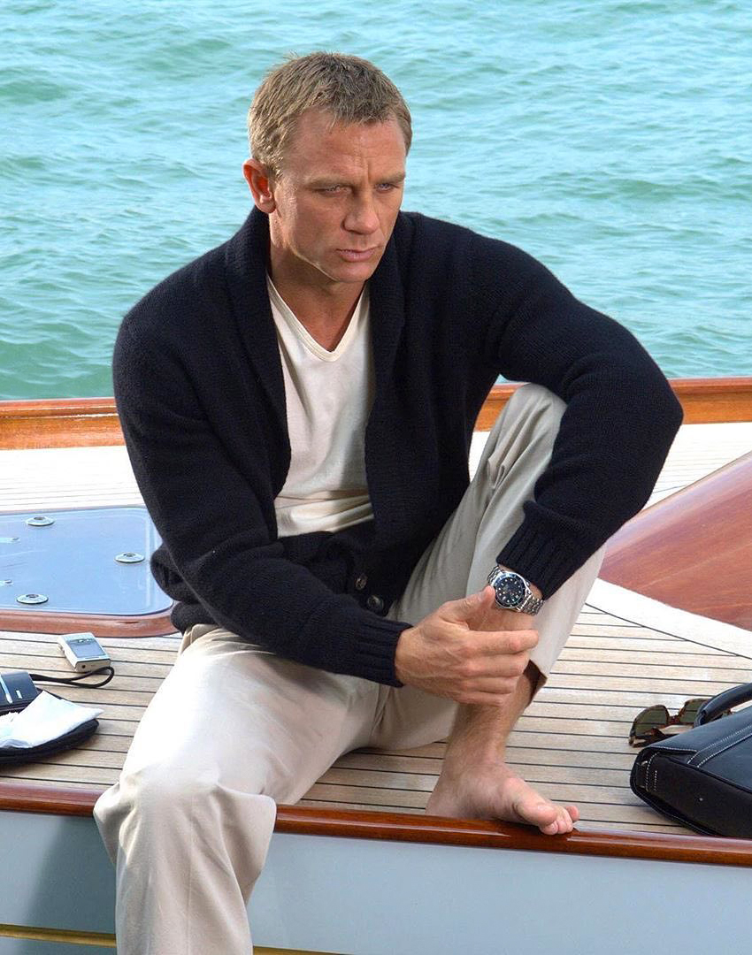 James Bond wear a black cardigan over a white t-shirt with tan chino pants