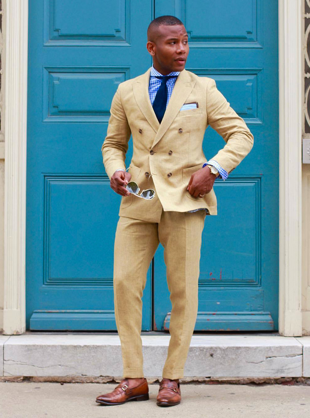 double-breasted khaki suit, blue shirt, and brown loafers